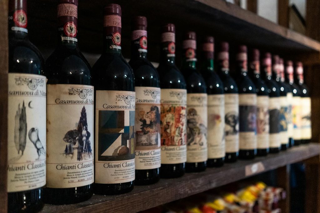 A close-up of Chianti Classico wine bottles neatly arranged on a cellar shelf in Florence, Italy.